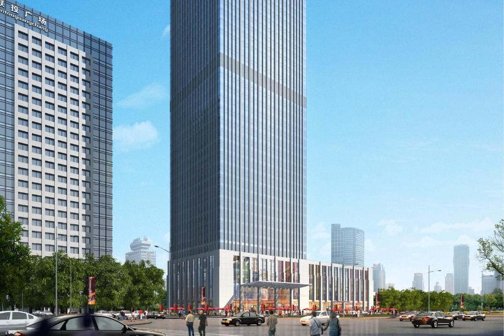 um edifício alto com pessoas a andar na frente dele em Four Points by Sheraton Wuhan, Jiangxia em Wuhan