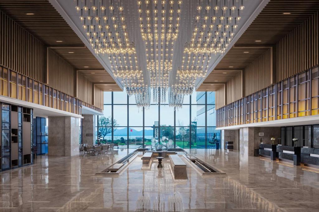 Un gran vestíbulo con una lámpara de araña en un edificio. en Xuzhou Marriott Hotel Lakeview, en Xuzhou