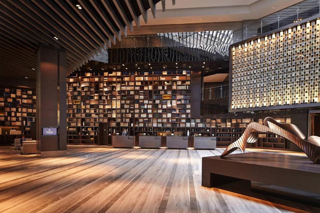 a library with a woman with her feet on a bench at Renaissance Beijing Wangfujing Hotel in Beijing