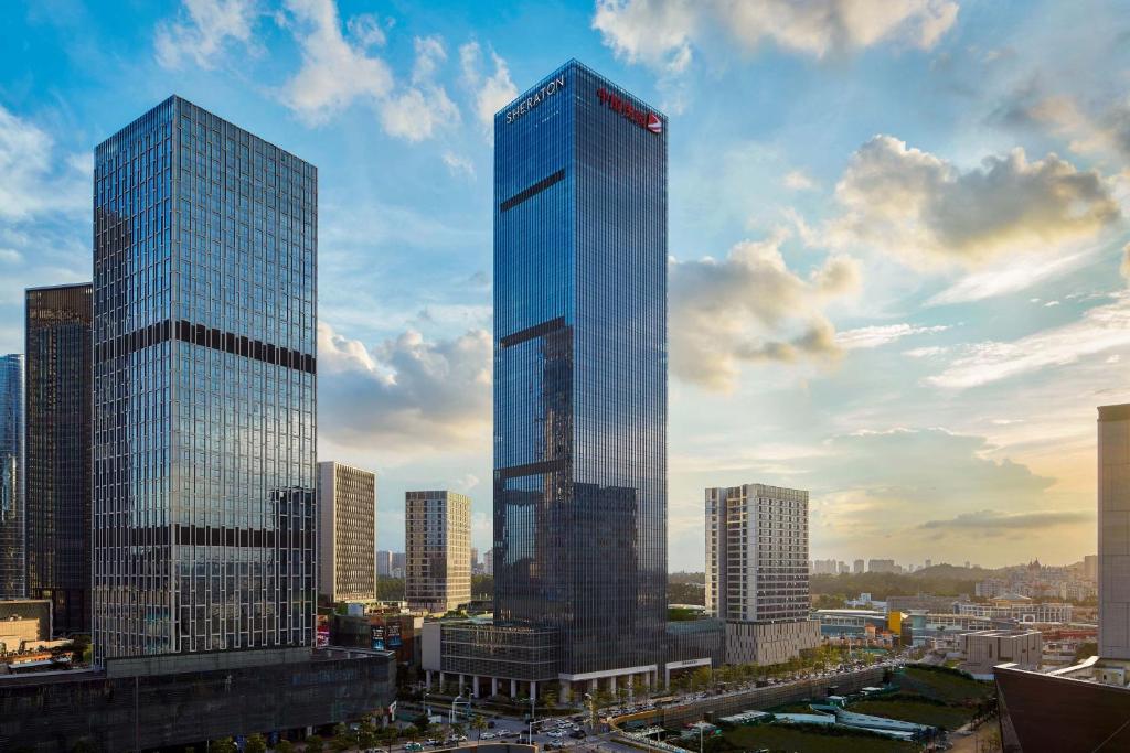 un haut gratte-ciel en verre dans une grande ville dans l'établissement Sheraton Guangzhou Panyu, à Canton