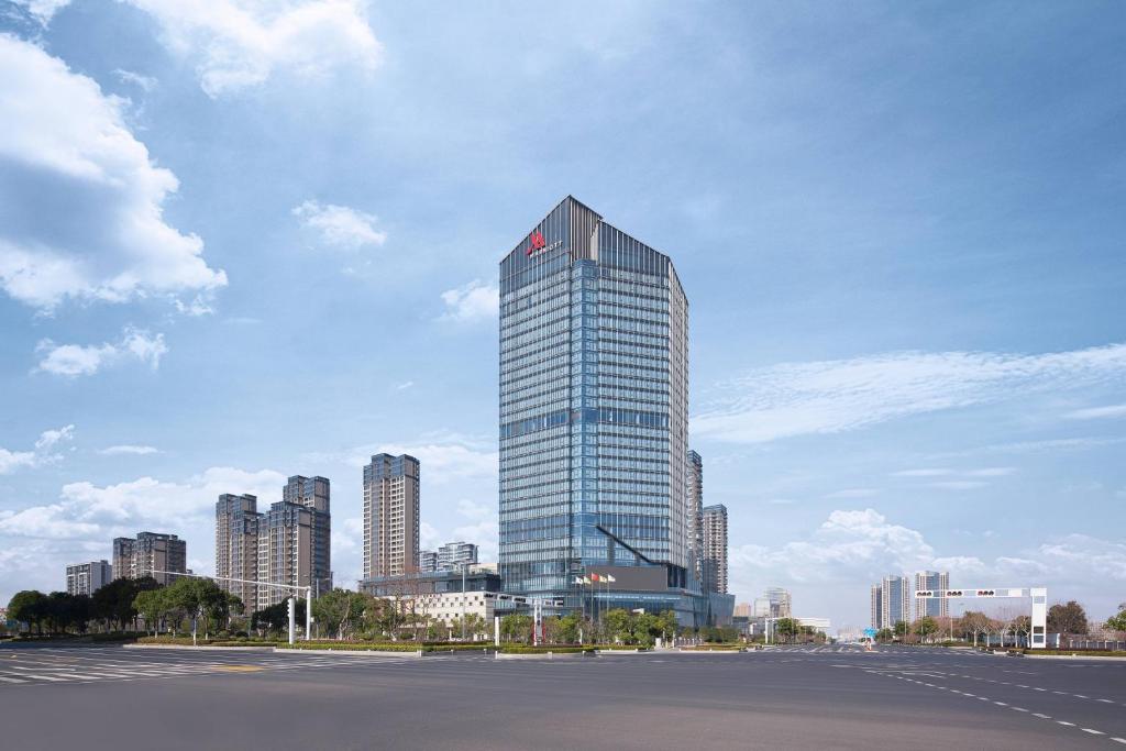 a tall glass building in front of a city at Liyang Marriott Hotel in Liyang
