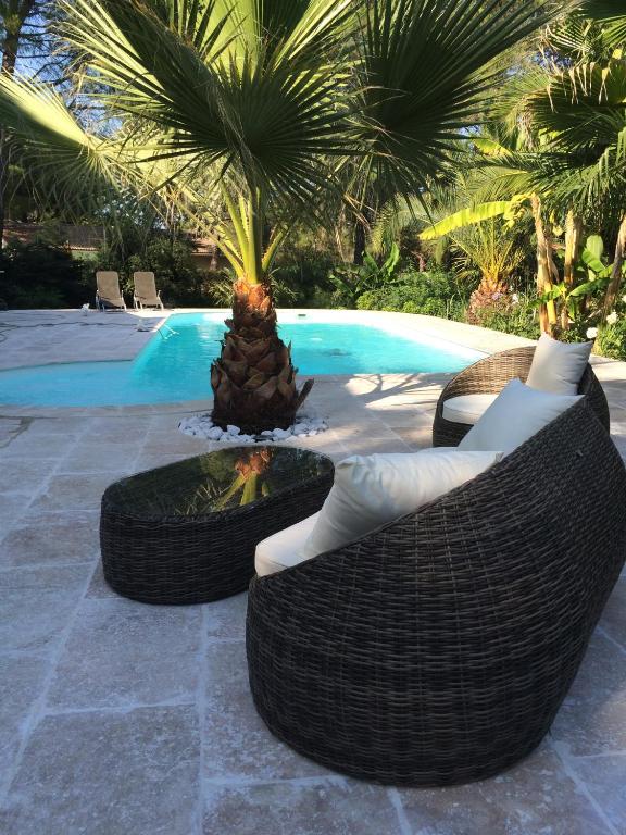 - une piscine avec 2 chaises longues et un foyer extérieur dans l'établissement Le Mazet De Trial, à Aubais