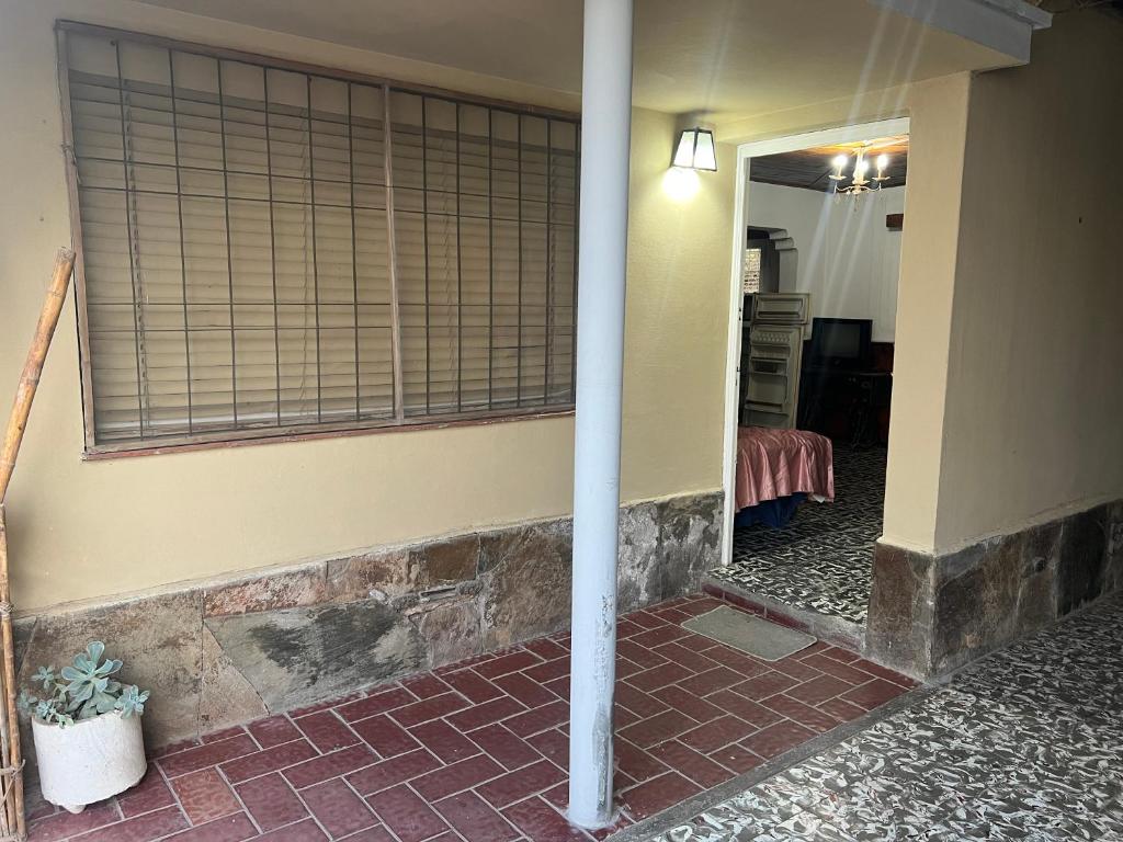 een gang van een huis met een pilaar en een spiegel bij Departamento en el corazón de Los Corralitos in Guaymallen