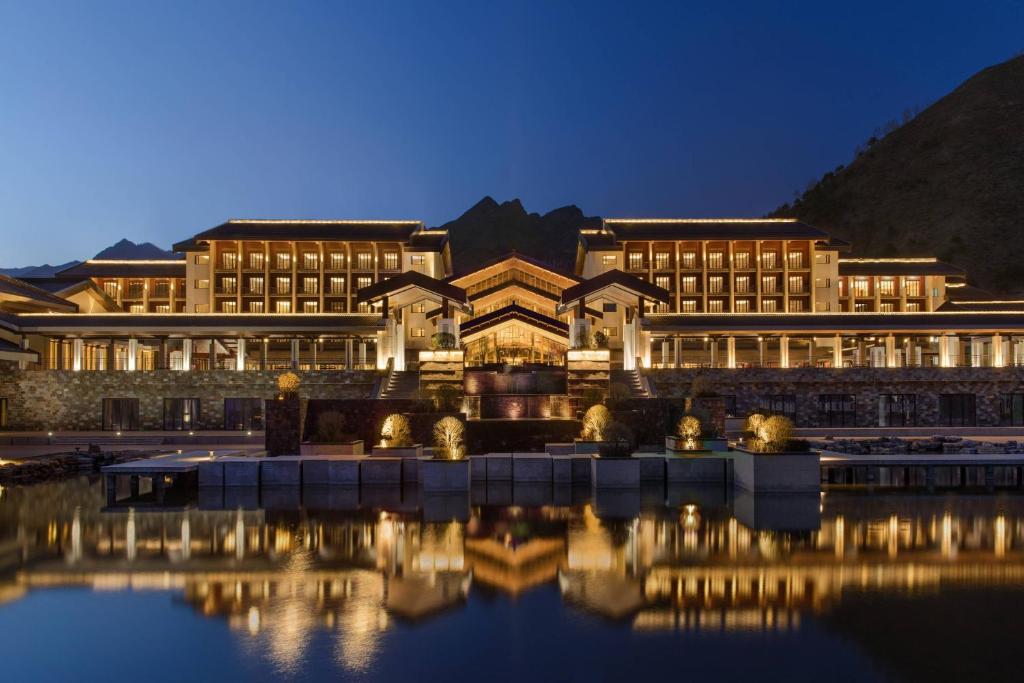 a building with a reflection in the water at night at Wutai Mountain Marriott Hotel in Wutai