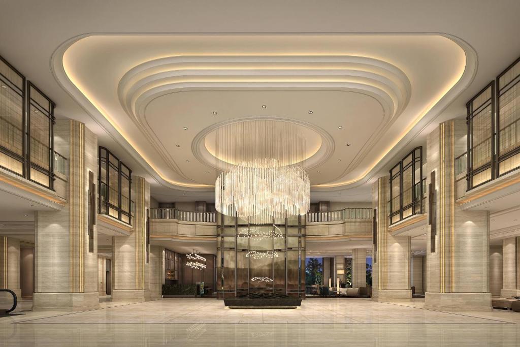 un gran vestíbulo con una gran lámpara de araña en un edificio en Zhejiang Taizhou Marriott Hotel en Taizhou