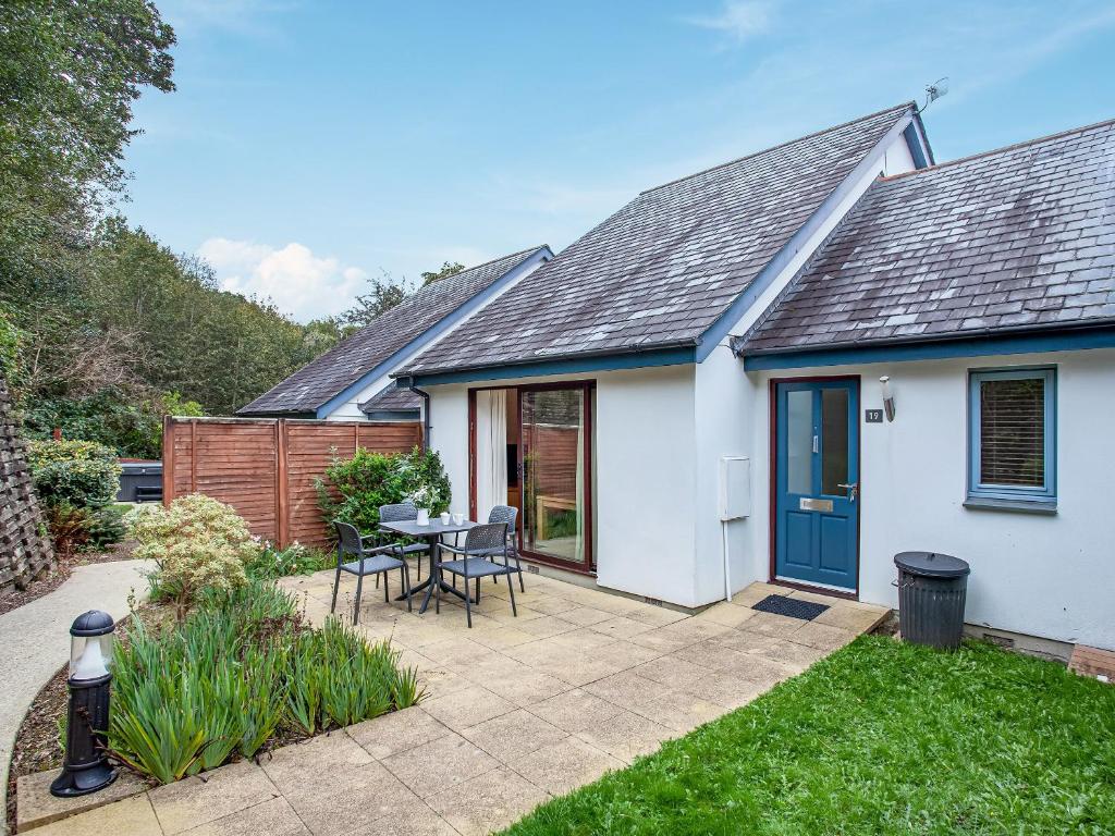 a white house with a blue door and a patio at Villa Gallery- 27073 in Perranwell