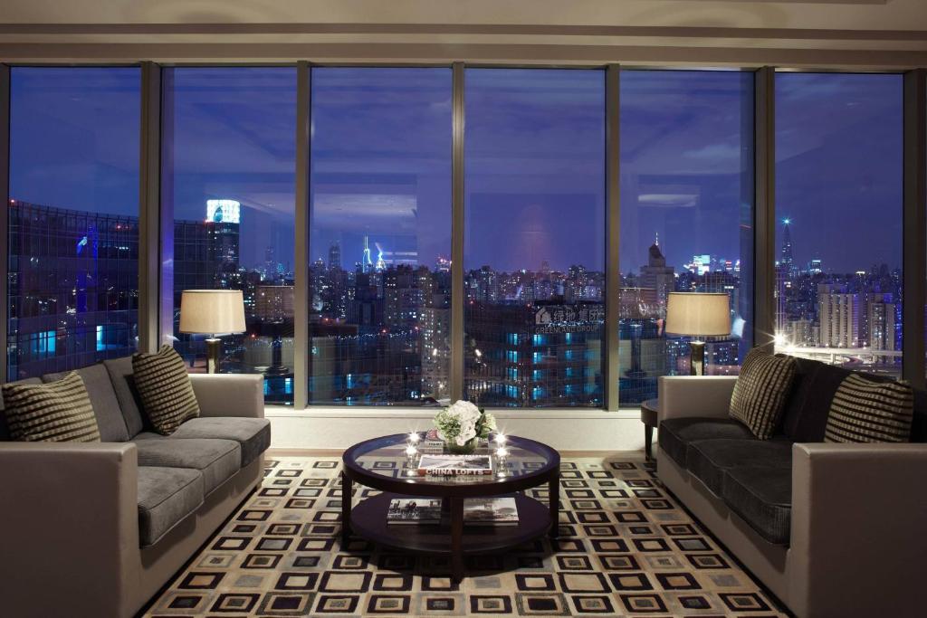 a large living room with a view of a city at Shanghai Marriott Hotel Riverside in Shanghai