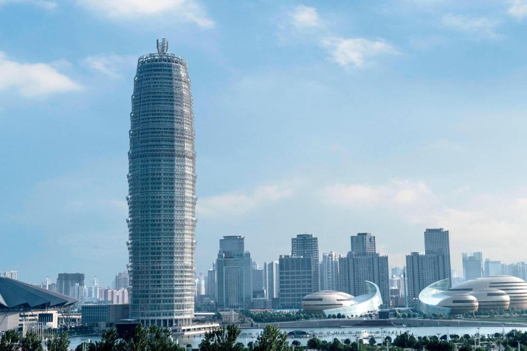 un edificio alto con una ciudad en el fondo en JW Marriott Hotel Zhengzhou en Zhengzhou