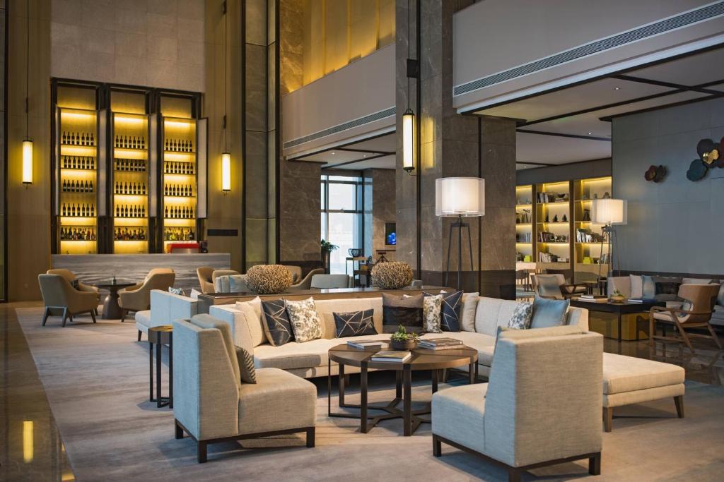 hol hotelowy z kanapami, krzesłami i stołami w obiekcie Chongqing Marriott Hotel w mieście Chongqing