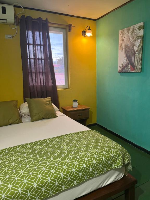 1 dormitorio con cama y ventana en Hostal Cay, en Bastimentos