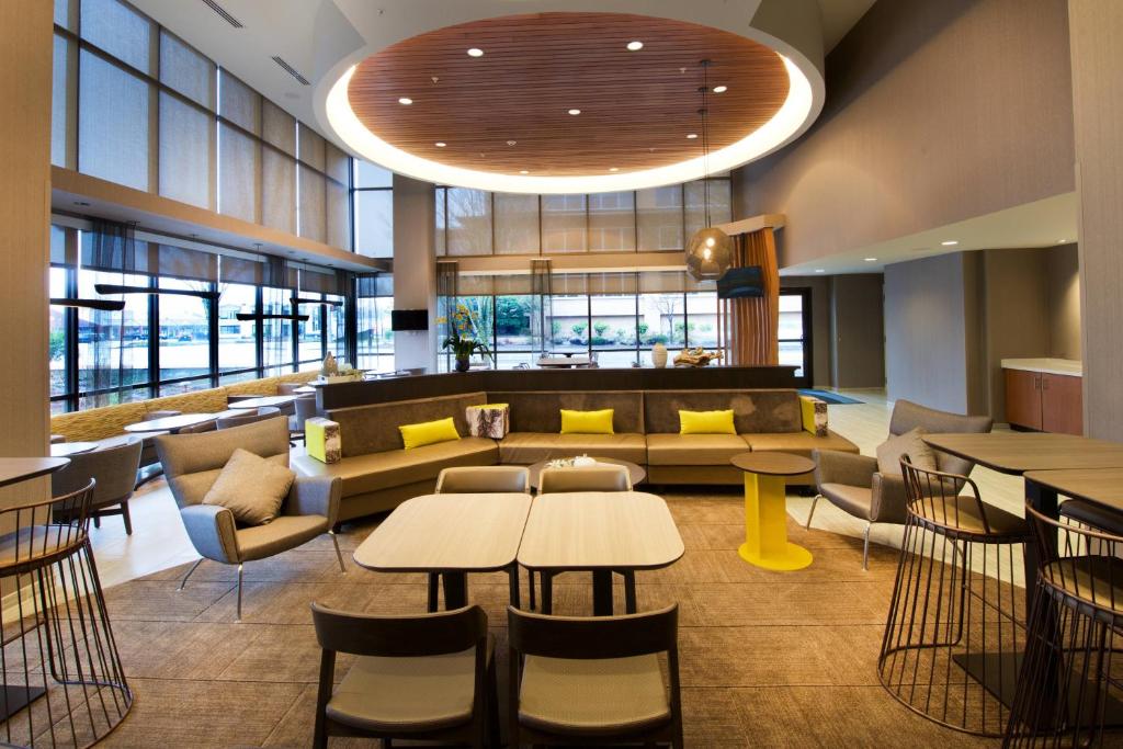 SpringHill Suites by Marriott Seattle Issaquah في إساكوا: لوبي به طاولات وكراسي وأريكة