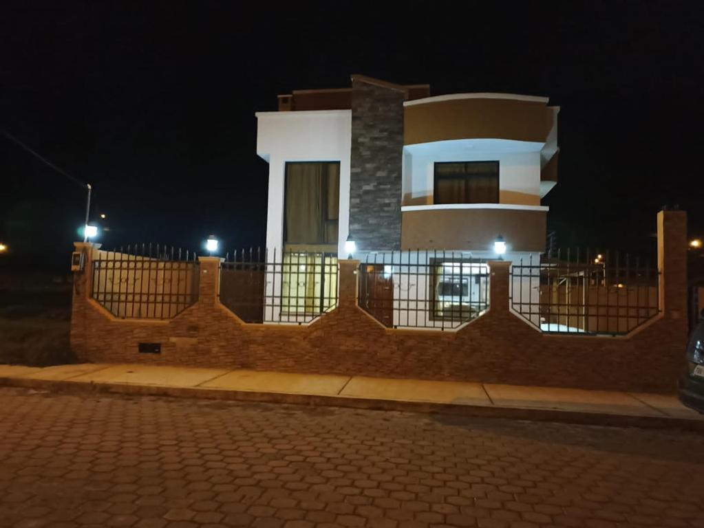 un edificio con una valla delante de él por la noche en Rondador Cotopaxi (Tanicuchí), en Tanicuchí