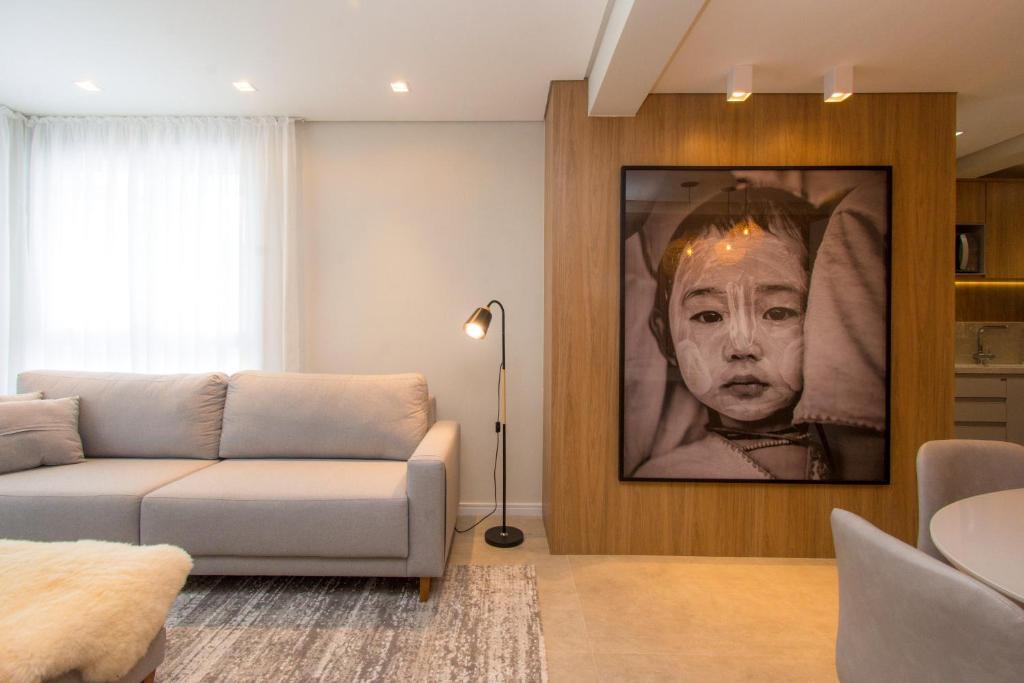 a living room with a couch and a picture of a woman at Villa di Tondo House II-Lindo apartamento in Bento Gonçalves