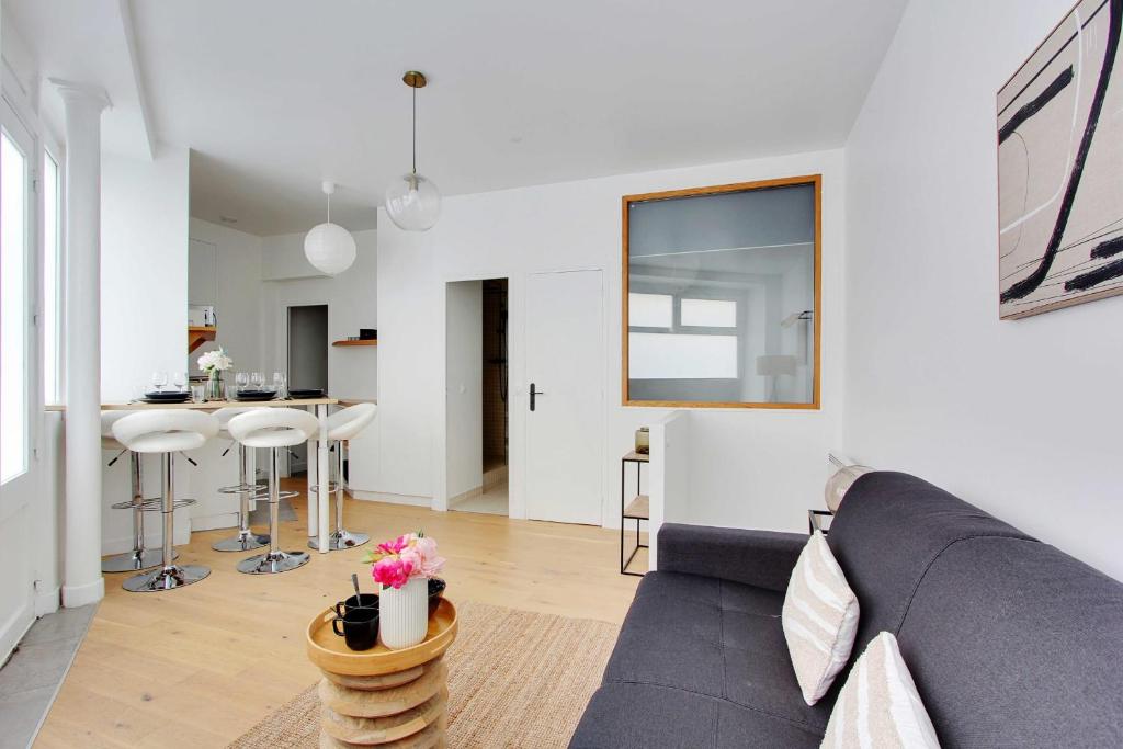 un salon avec un canapé et une table dans l'établissement Accueillant et moderne - 2BR 4P - Sacré Coeur, à Paris