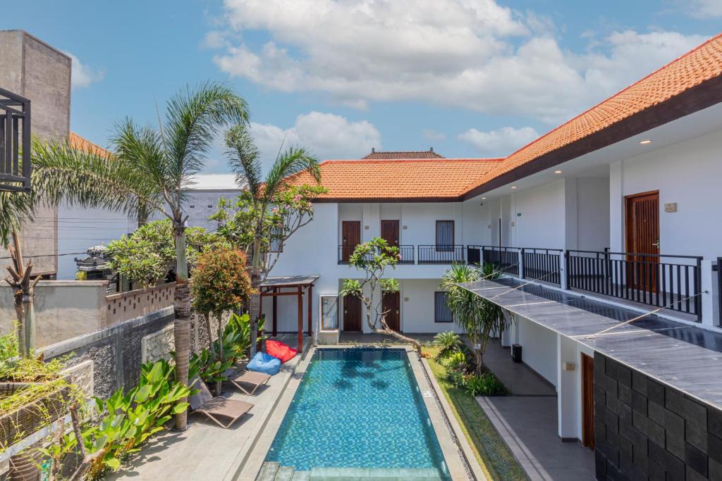 uma vista para a piscina a partir da varanda de uma casa em The Baliem Hotel em Jimbaran