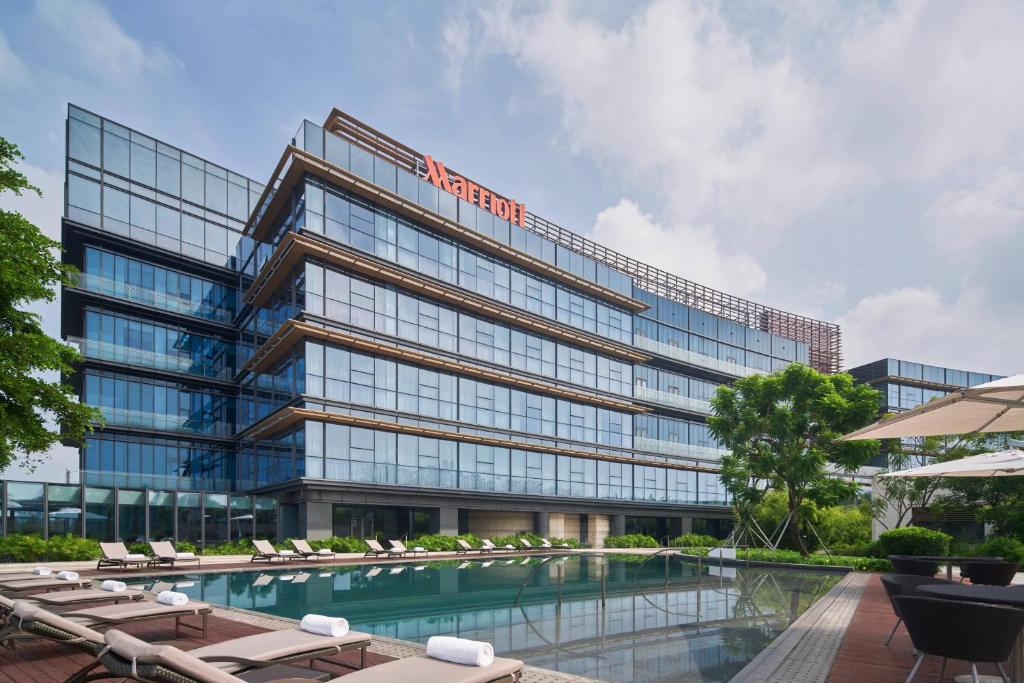 um edifício de escritórios com uma piscina em frente em The OCT Harbour, Shenzhen - Marriott Executive Apartments em Shenzhen
