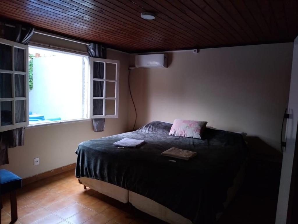 um quarto com uma cama e uma janela em Geriba surfing em Búzios