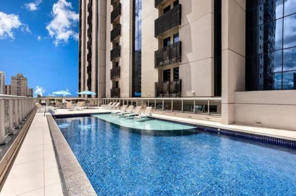 a hotel swimming pool with chairs and buildings at 511. Flat Hotel S4 in Brasilia