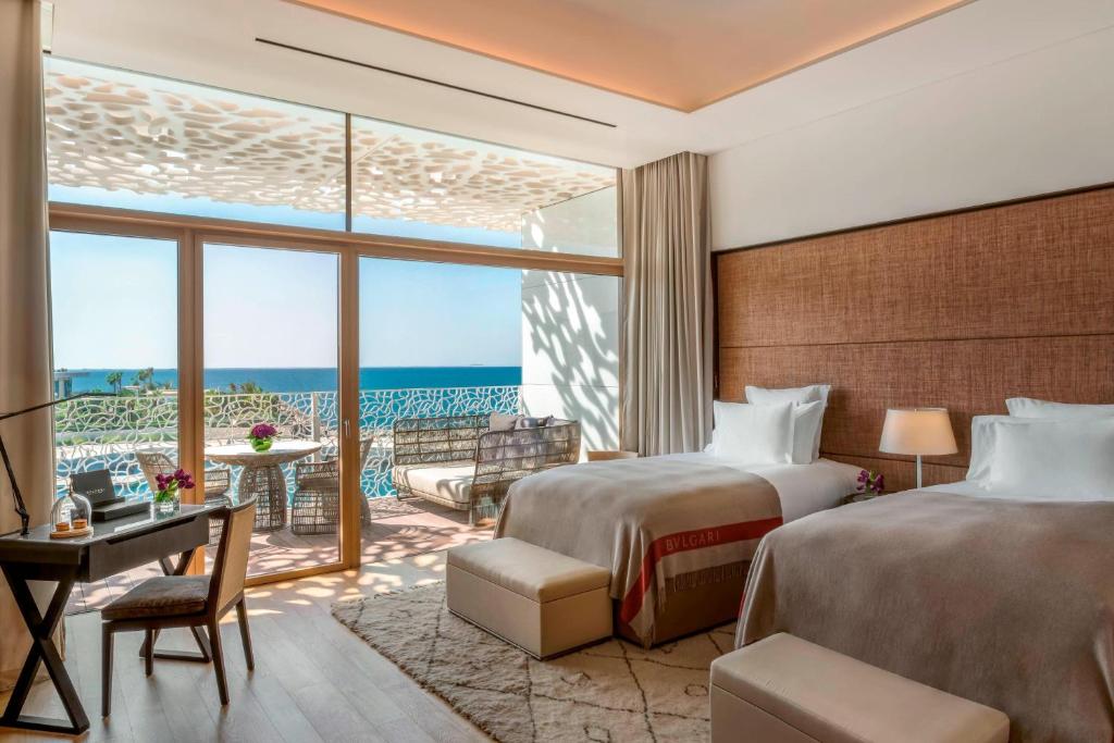 a hotel room with two beds and a view of the ocean at Bulgari Resort, Dubai in Dubai