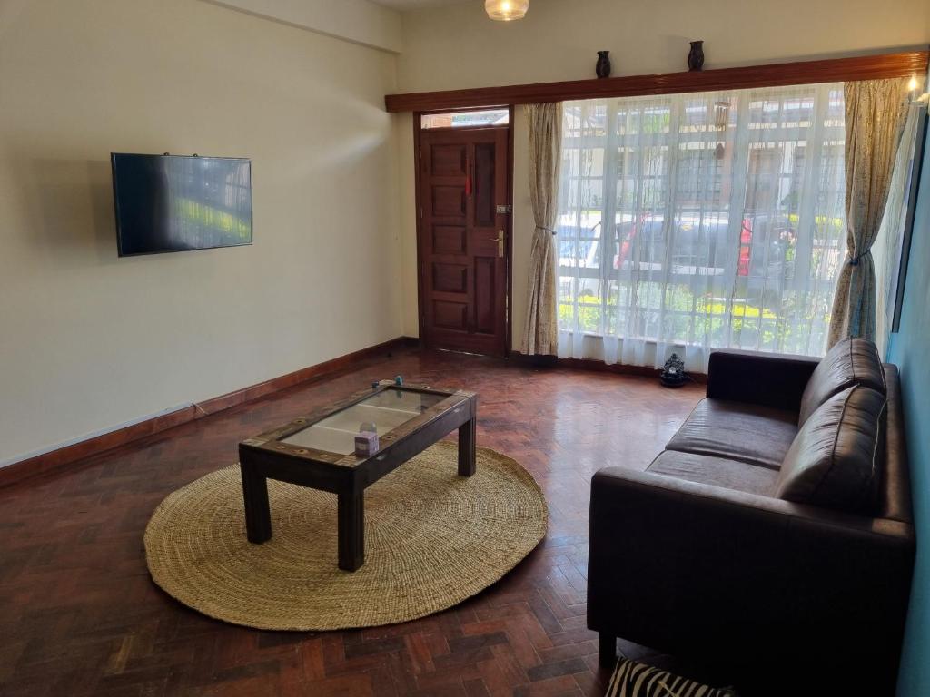 sala de estar con sofá y mesa de centro en Shared Apartment with the best entertainment spots, en Nairobi