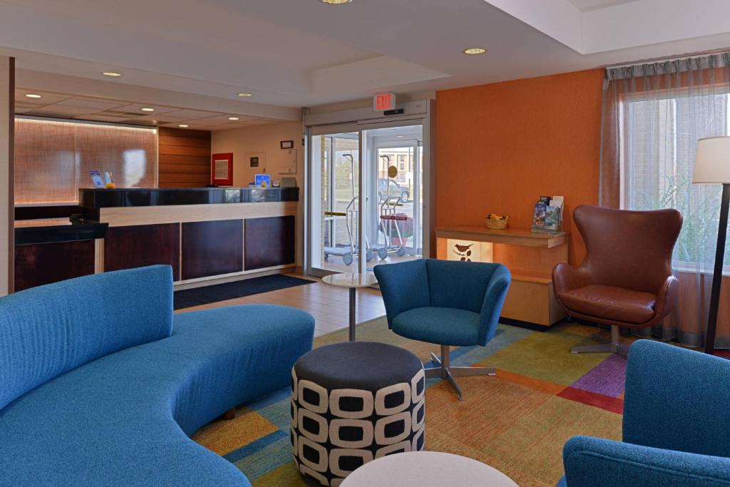 a waiting room with a blue couch and chairs at Fairfield Inn and Suites by Marriott Dayton Troy in Troy