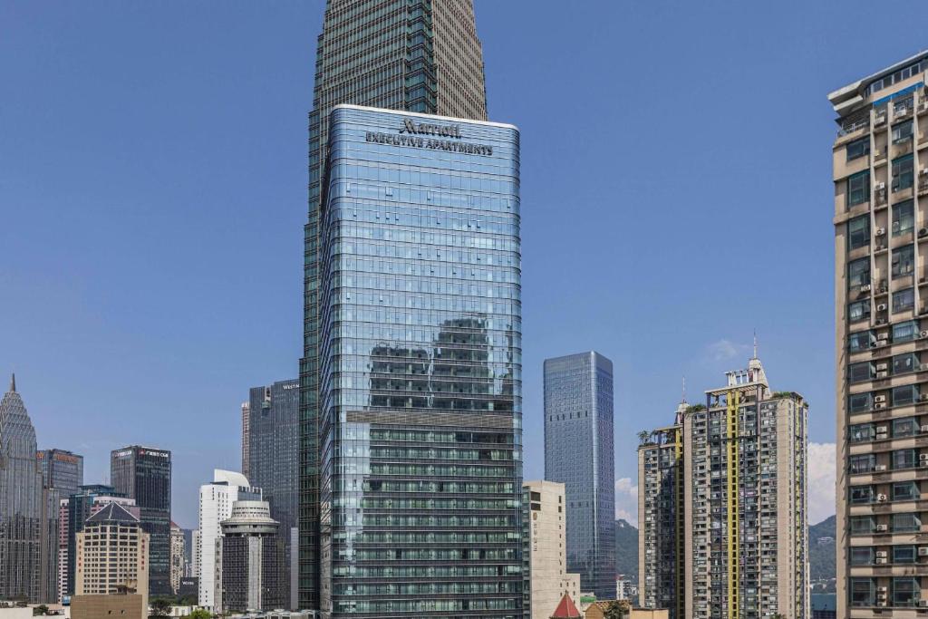 wysoki szklany budynek w dużym mieście w obiekcie Marriott Executive Apartments Chongqing w mieście Chongqing