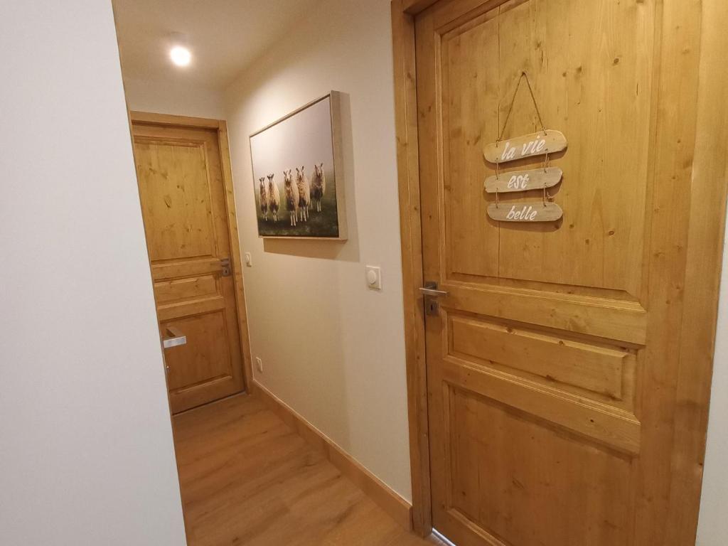 a hallway with a wooden door and a pair of shoes at Appartement Valmorel, 3 pièces, 5 personnes - FR-1-356-422 in Valmorel