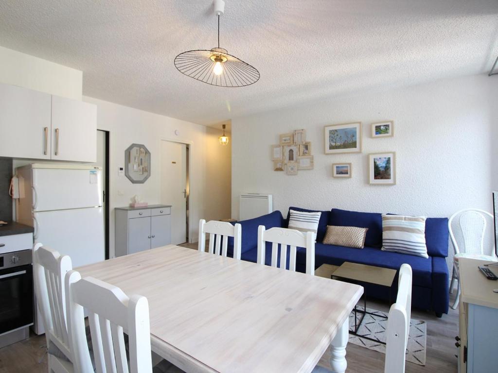 Il comprend une cuisine et un salon avec une table et un canapé bleu. dans l'établissement Appartement Mont-Dore, 3 pièces, 5 personnes - FR-1-608-255, à Le Mont-Dore