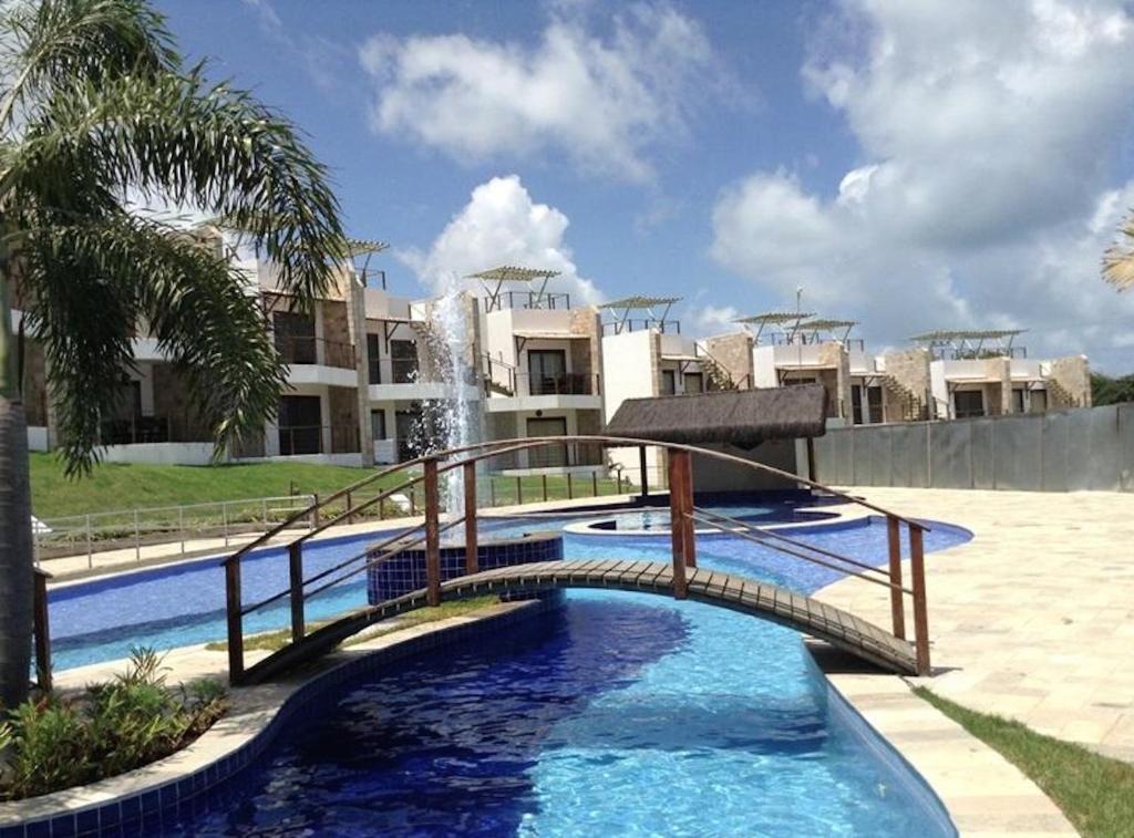 une piscine avec un pont en face d'un bâtiment dans l'établissement Dream Away Pipa Residence, à Pipa