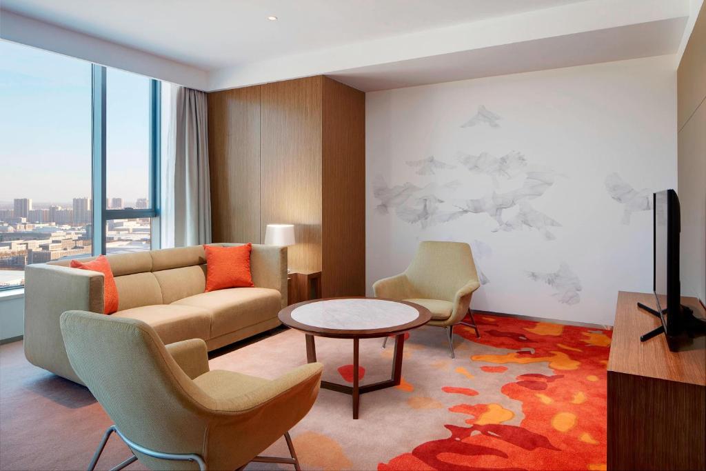 a living room with a couch and chairs and a table at Four Points by Sheraton Changchun Hi-Tech Zone in Changchun