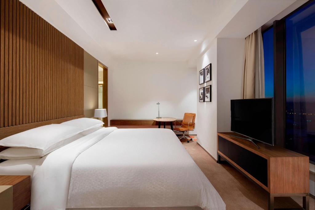 a bedroom with a large bed and a television at Four Points by Sheraton Changchun Hi-Tech Zone in Changchun