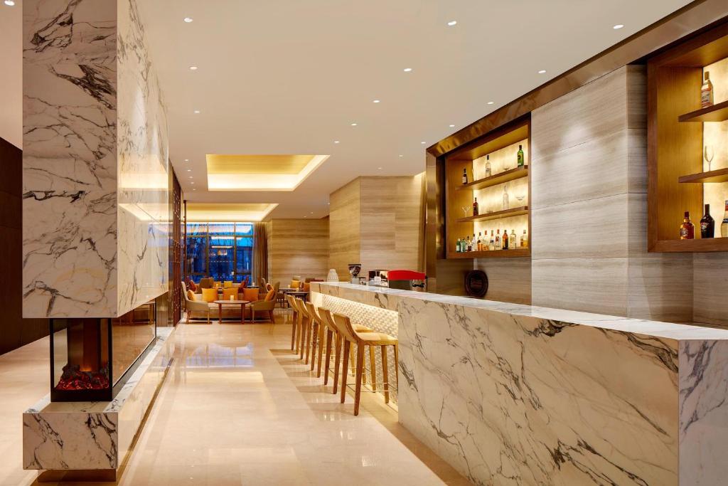 a bar in a restaurant with a marble counter at Four Points by Sheraton Changchun Hi-Tech Zone in Changchun