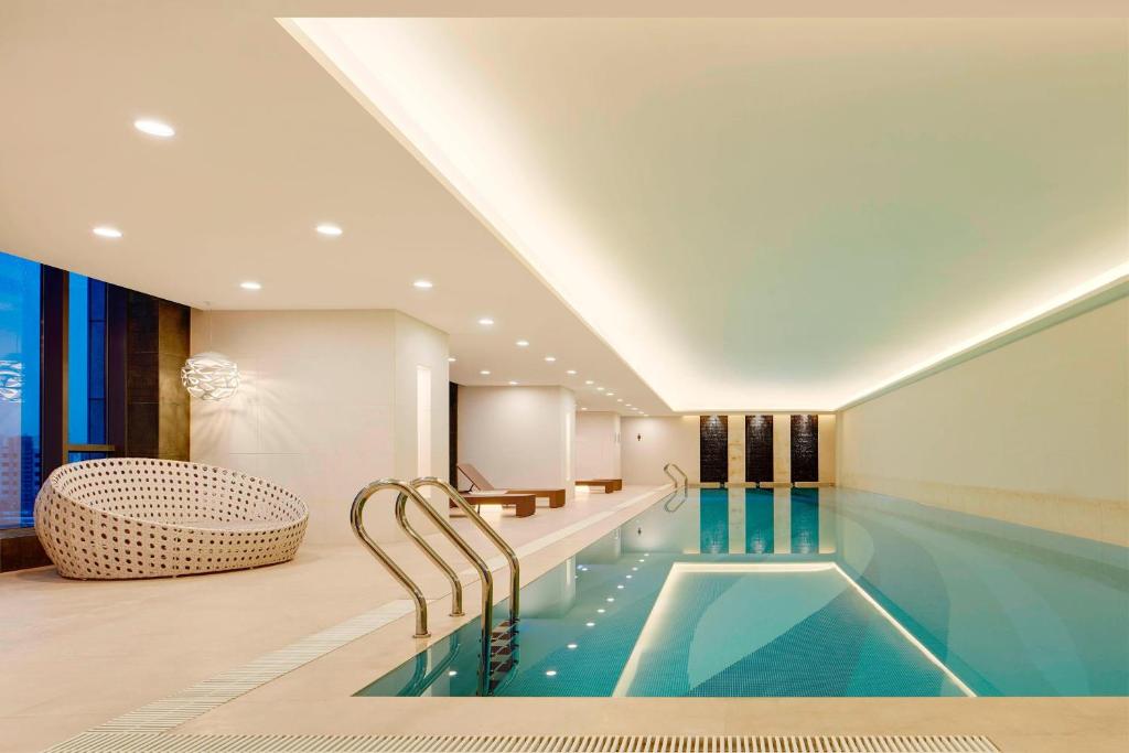 a swimming pool in a hotel room with a tub at Four Points by Sheraton Changchun Hi-Tech Zone in Changchun