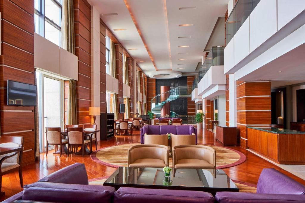 a lobby with a couch and chairs and tables at Sheraton Zhoushan Hotel in Zhoushan