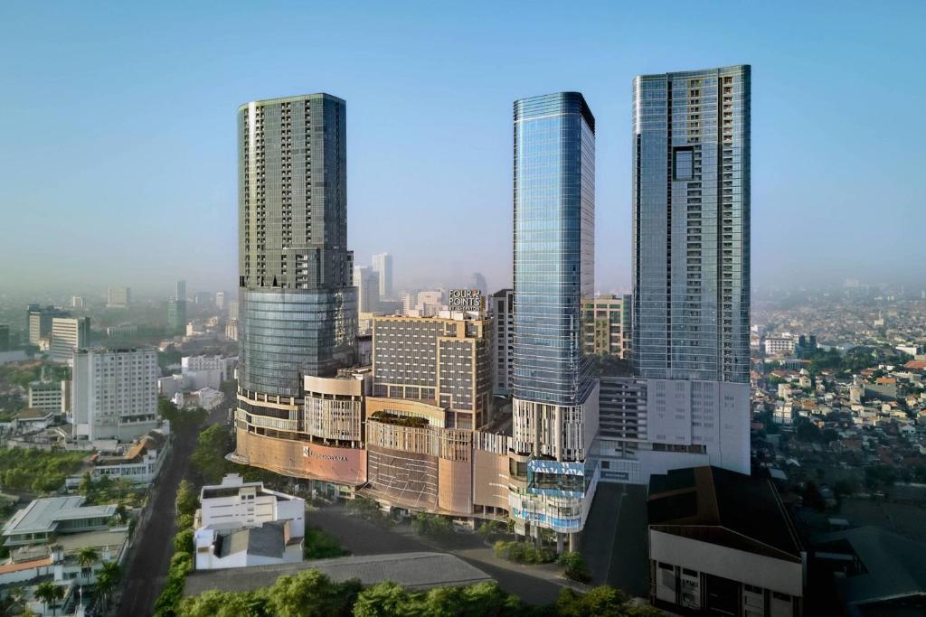 three tall skyscrapers in a city with buildings at Four Points by Sheraton Surabaya, Tunjungan Plaza in Surabaya