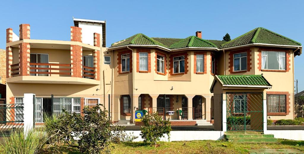 a large brick house with a green roof at Tarkshay Hospitality in Densainagar