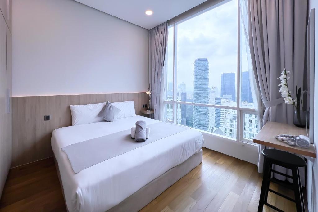 a hotel room with a large bed and a large window at Soho Suites KLCC by Leala in Kuala Lumpur