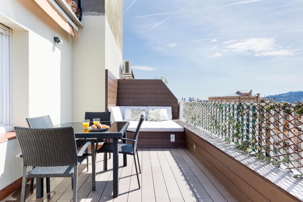 巴塞隆納的住宿－Stay U-nique Apartments Rambla Catalunya IV，阳台配有桌椅和1张床。