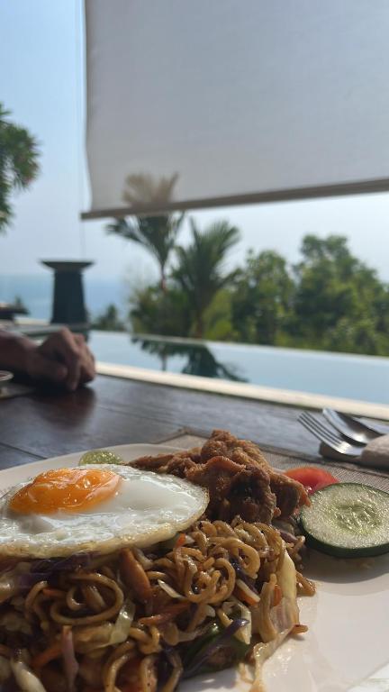 a plate of food with an egg on a table at The Puncak Lombok in Senggigi