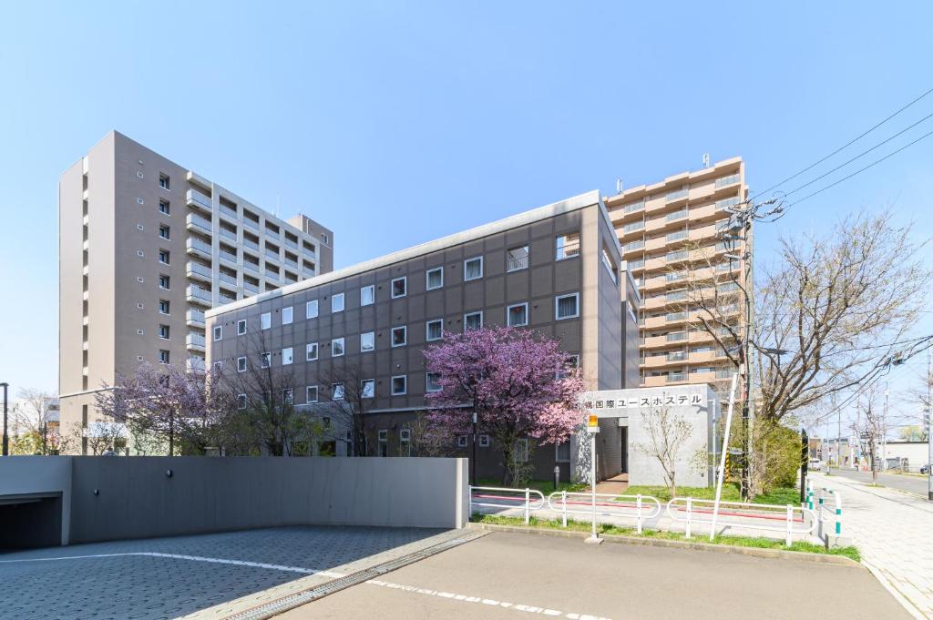 an empty parking lot in front of a building at Sapporo International Youth Hostel in Sapporo