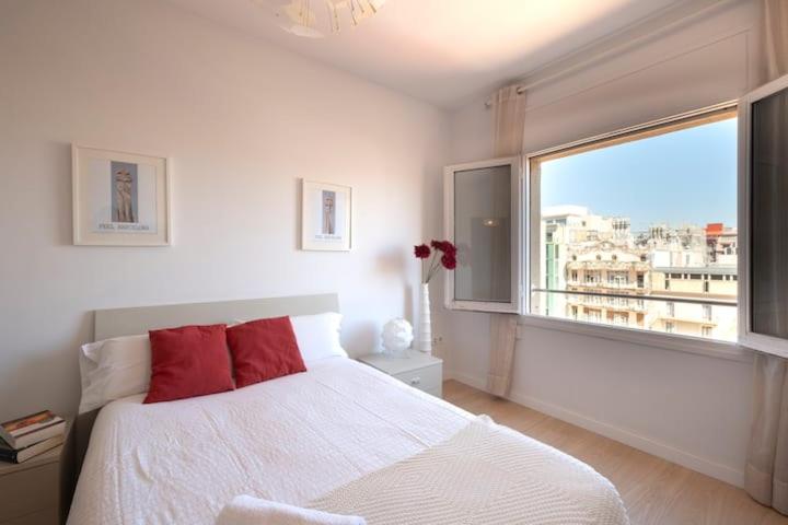 a bedroom with a white bed and a large window at Stay U-nique Apartments Rambla Catalunya V in Barcelona