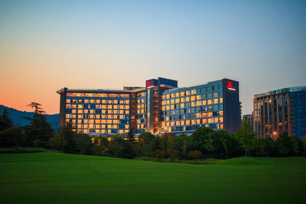 een groot gebouw met een veld ervoor bij Suzhou Marriott Hotel Taihu Lake in Suzhou