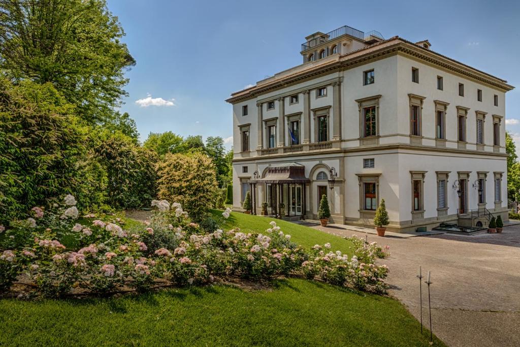 un grande edificio bianco con dei fiori di fronte di Villa Cora a Firenze