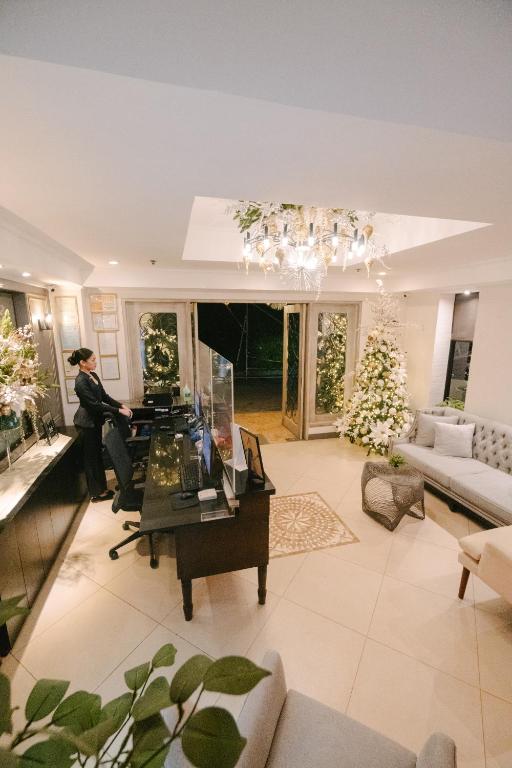a woman is standing in a living room at Sta Barbara Residence Hotel in Cebu City