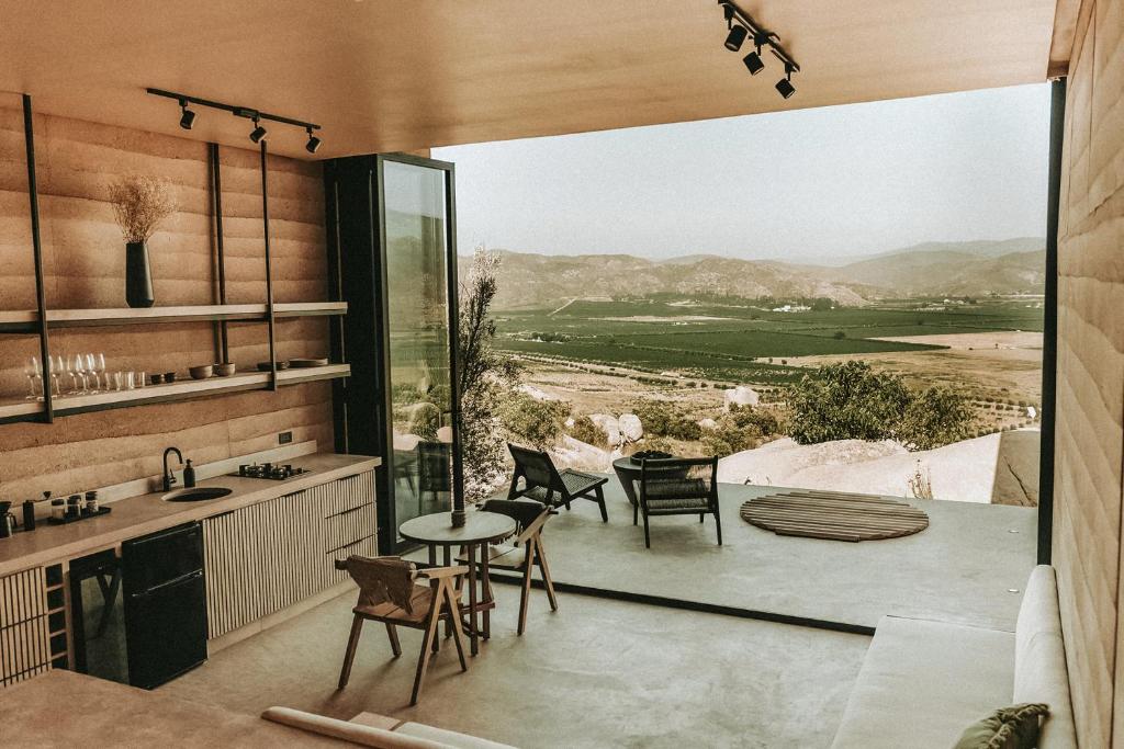 eine Küche mit einem Tisch und Stühlen sowie einem großen Fenster in der Unterkunft MIRA Earth Studios in San Antonio de las Minas