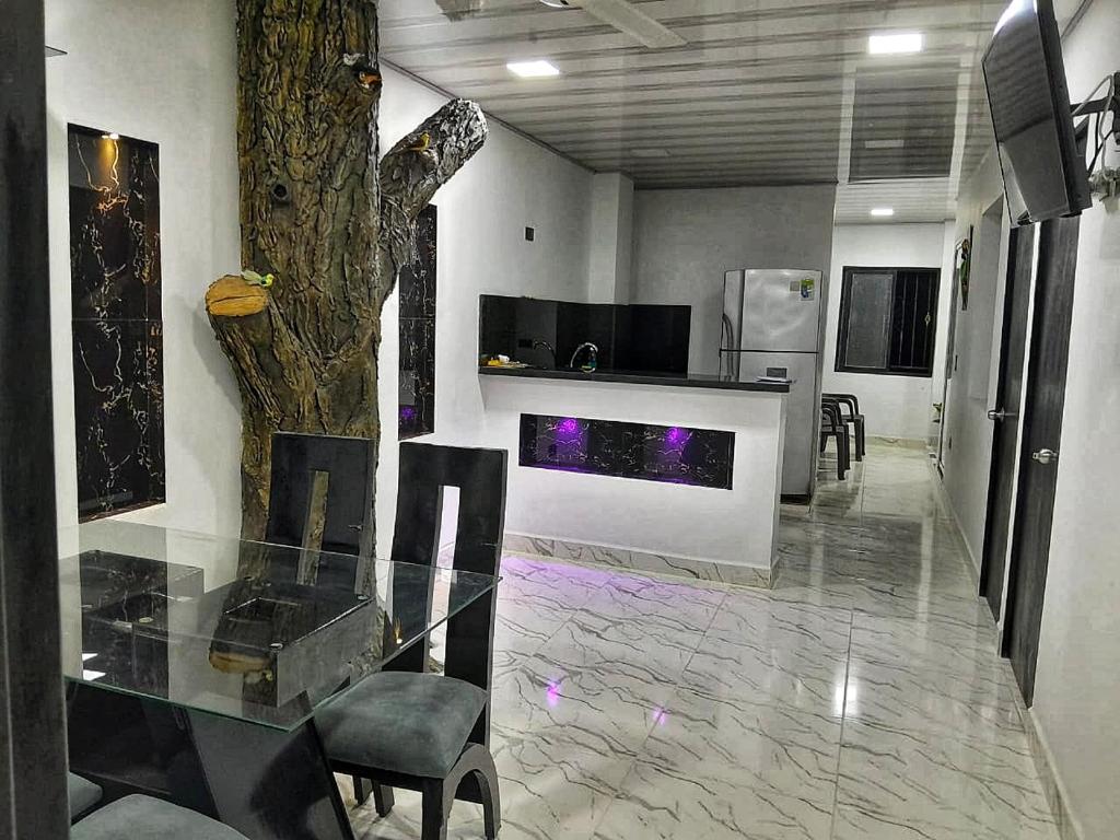 ein Esszimmer mit einem Glastisch und einem Baum in der Unterkunft CASA DEL ARBOL in Doradal
