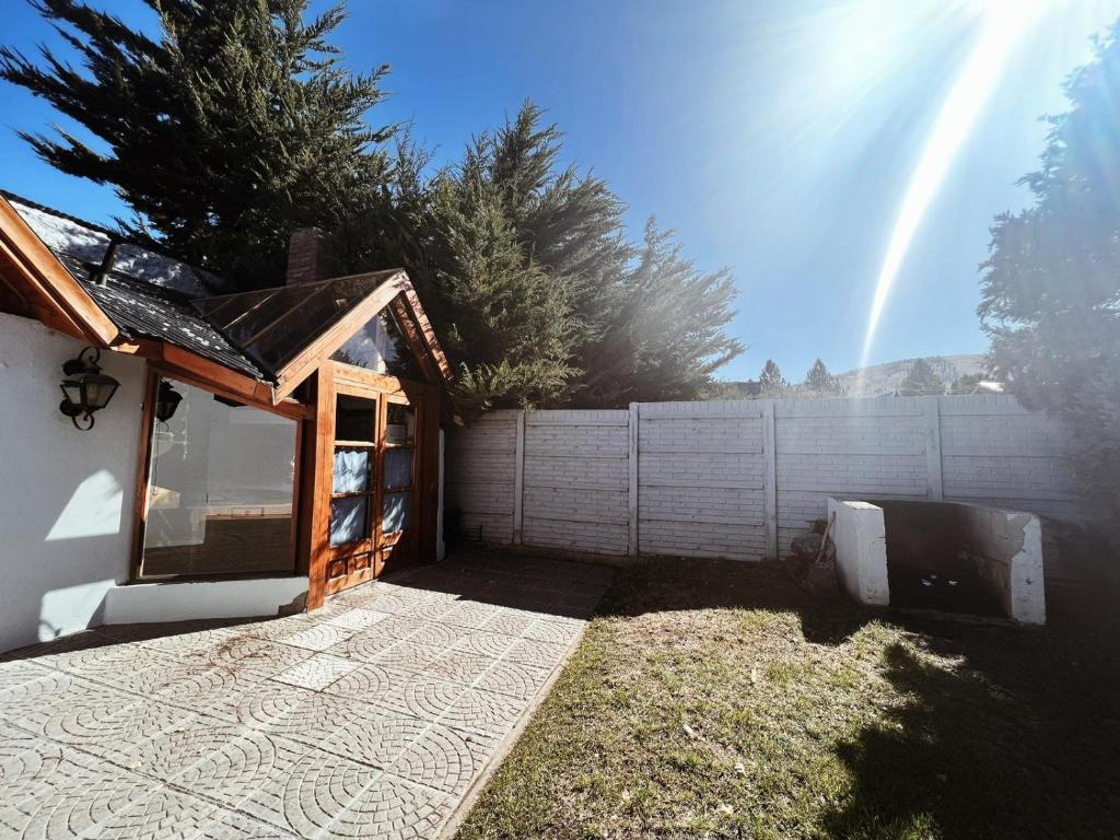 a small house with a fence and a fence at Casa Arrayanes Tempo in Esquel