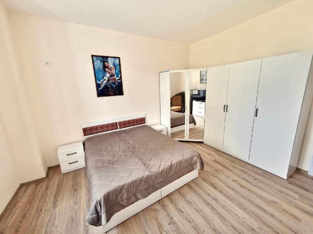 um quarto com uma cama e armários brancos em Апартаменти Москва em Dobrich