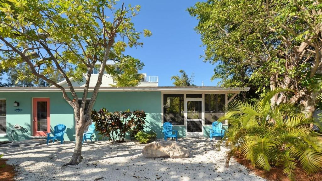 a house on the beach with chairs and trees at Minnow 2 Villa in Anna Maria