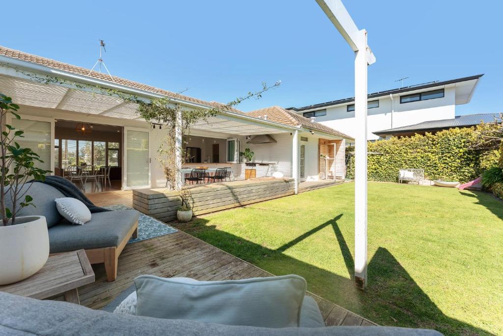 a backyard with a couch and a lawn at Belle Escapes - Beauty at the Beach in Glenelg